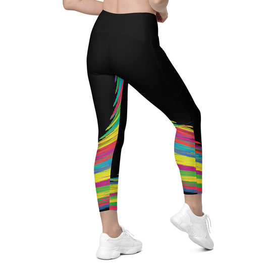 Back angled view of black crossover leggings with bright multicolor brushstroke design and high crossover waistband