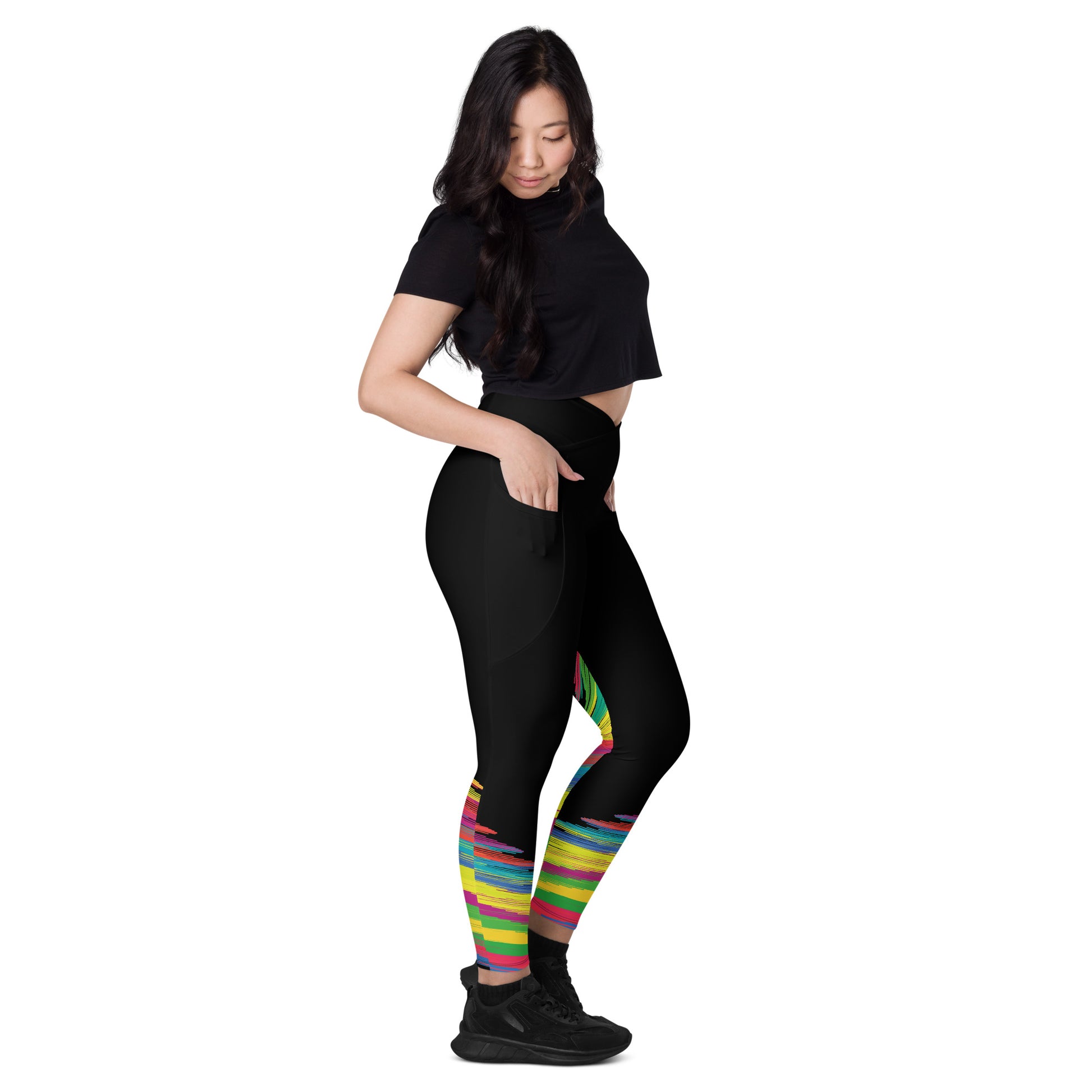 Side view of woman wearing black crossover leggings with colorful abstract brushstroke pattern around the calves