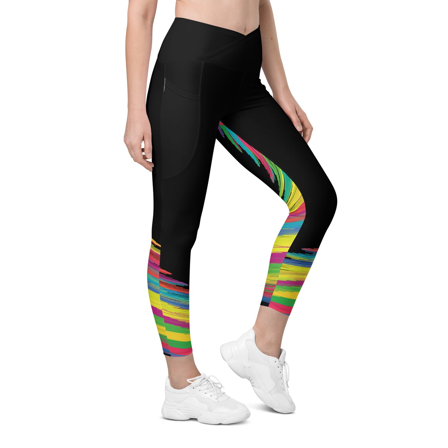 Front view of woman wearing black crossover leggings with colorful brushstroke pattern on the lower legs and side pockets