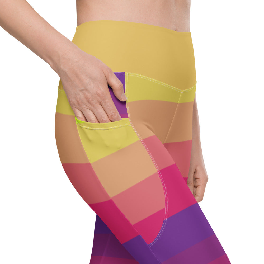Close-up of women's striped leggings showing side pocket and bright yellow pink purple and coral pattern