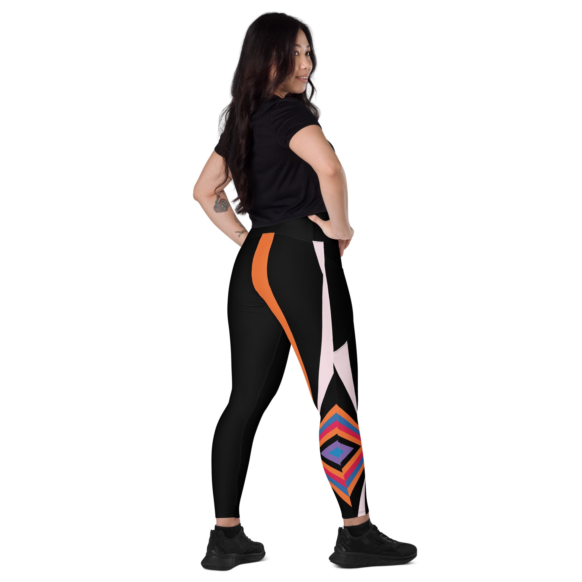 Rear view of woman wearing black leggings with orange side panel and multicolor geometric diamond pattern