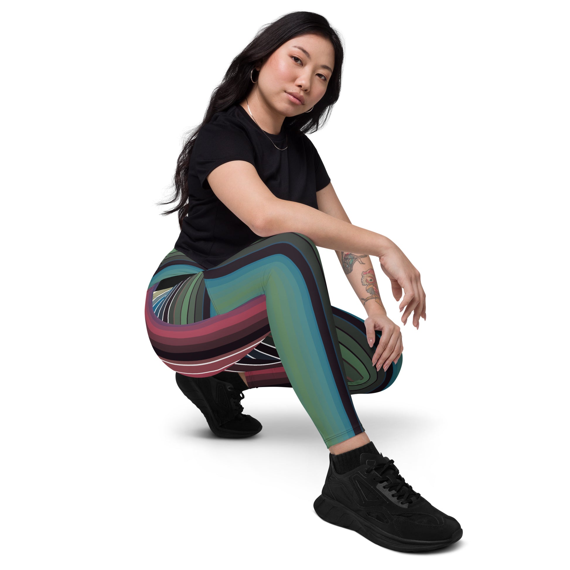 Woman crouching in multicolor retro striped leggings with flowing curved line design