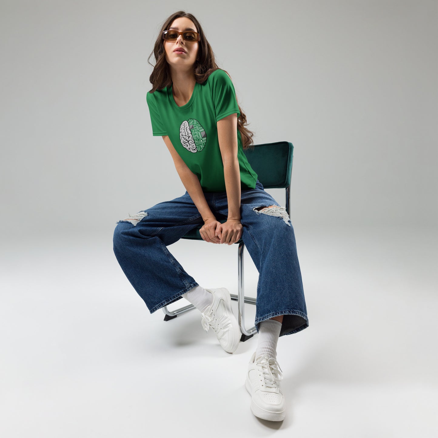 Woman seated wearing green Nonbinary Women graphic T-shirt with brain and technology design