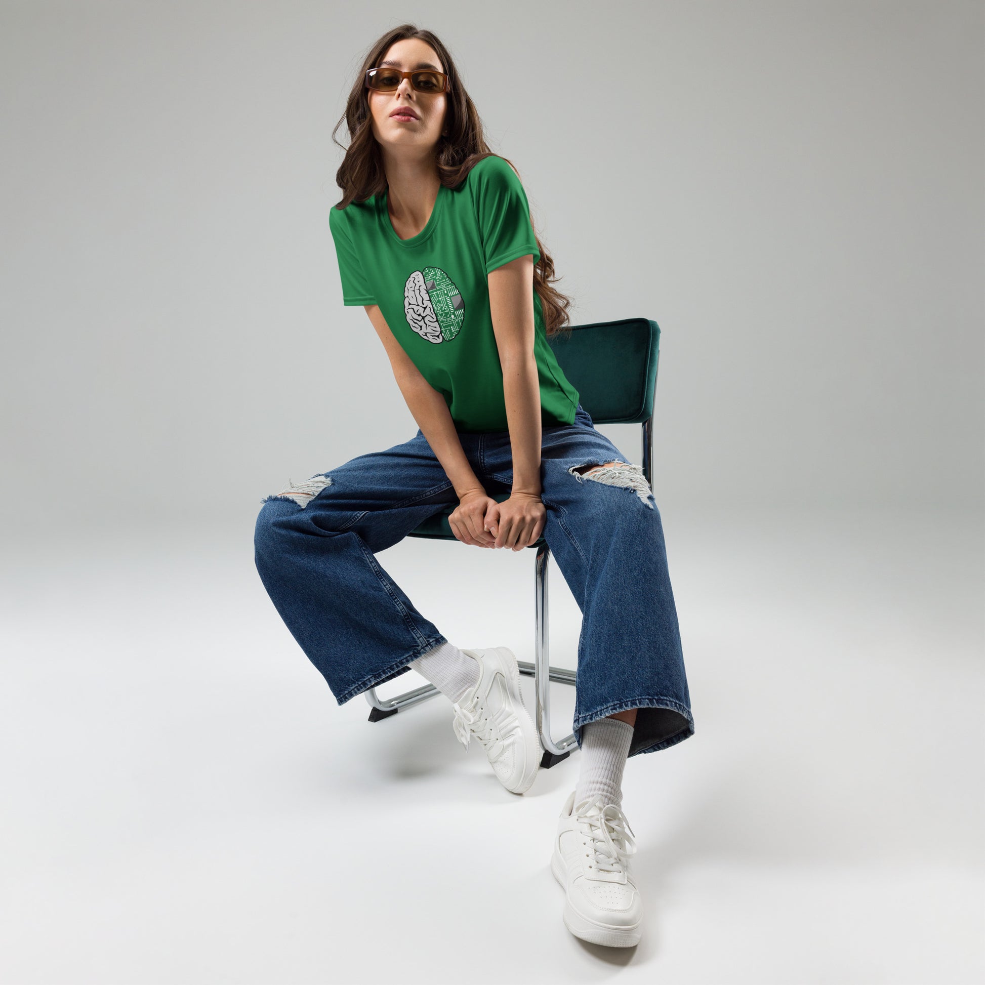 Woman seated wearing green Nonbinary Women graphic T-shirt with brain and technology design