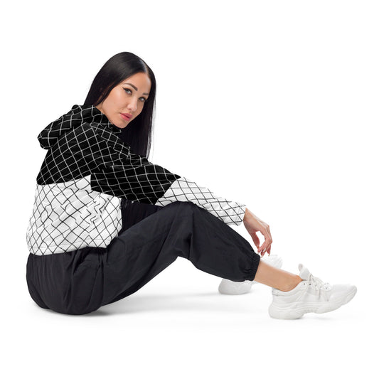 Woman wearing black and white geometric grid cropped windbreaker with hood and color-block design