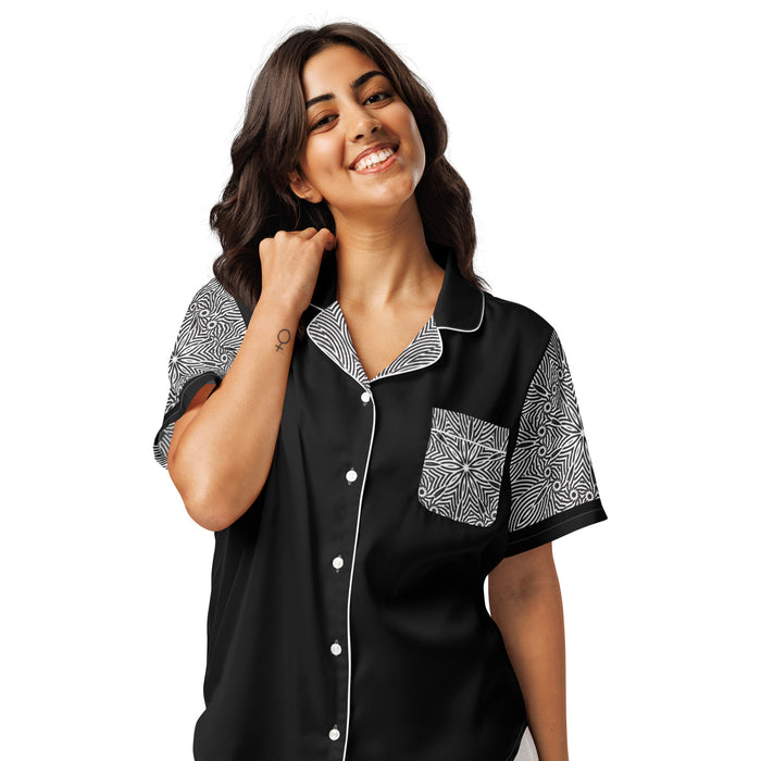 Woman wearing black women's short sleeve pajama top with black and white floral patterned sleeves and pocket