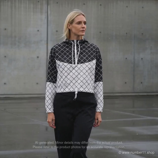 AI-generated video of a blonde woman wearing a black and white diamond-grid cropped windbreaker on a wet urban pavement, ending with a close-up of the front.