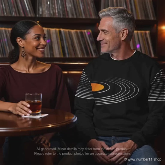 AI-generated video of a man wearing a black vinyl-record sweatshirt beside a woman in a retro music bar, ending with a close-up of the print.