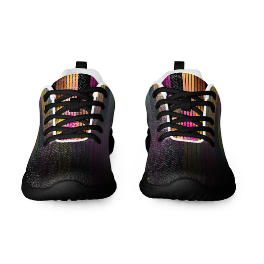 Front view of women’s athletic shoes with dark vertical line pattern, black laces, black sole, and muted multicolor accents