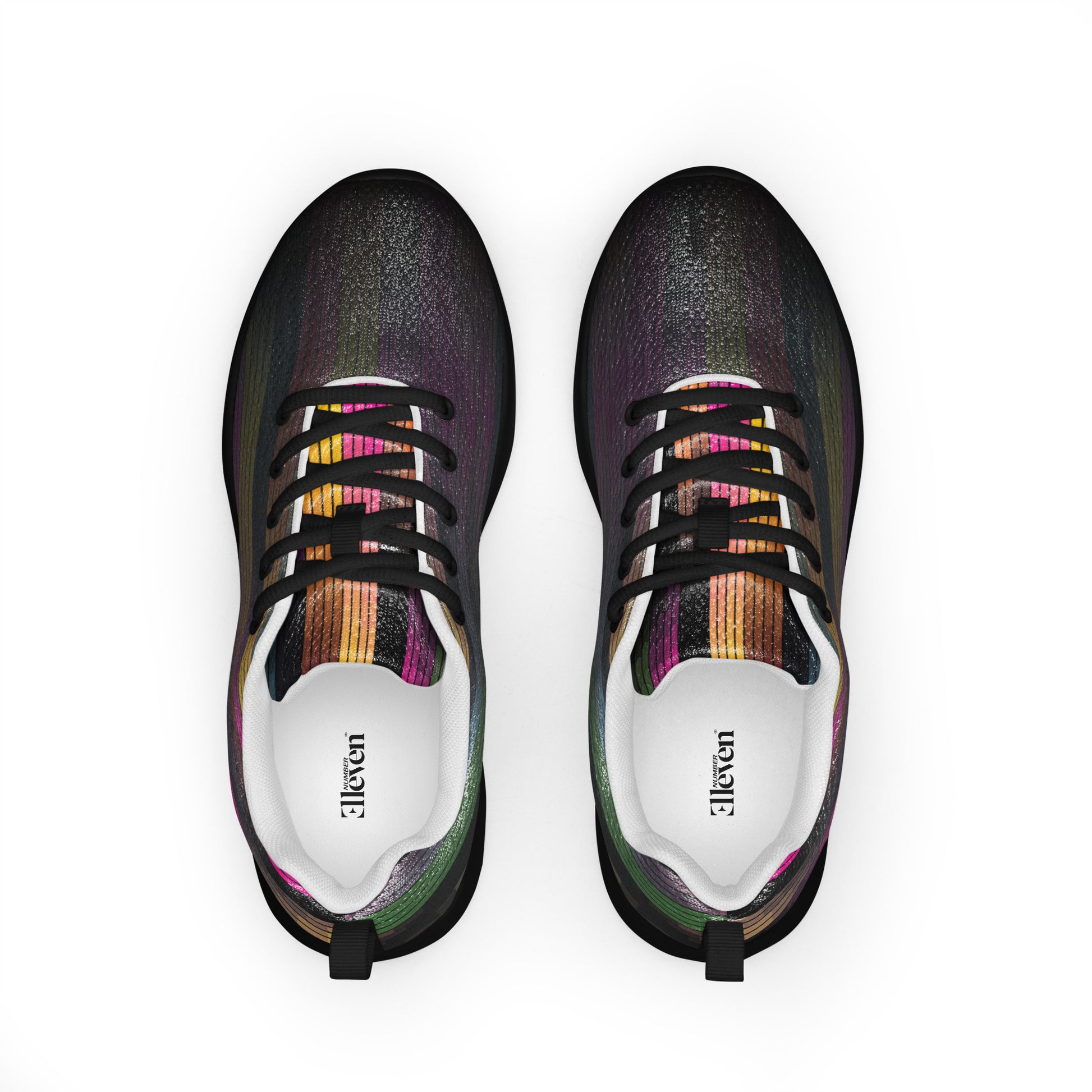 Top view of women’s athletic shoes with dark textured surface, black laces, and subtle spectrum color line details