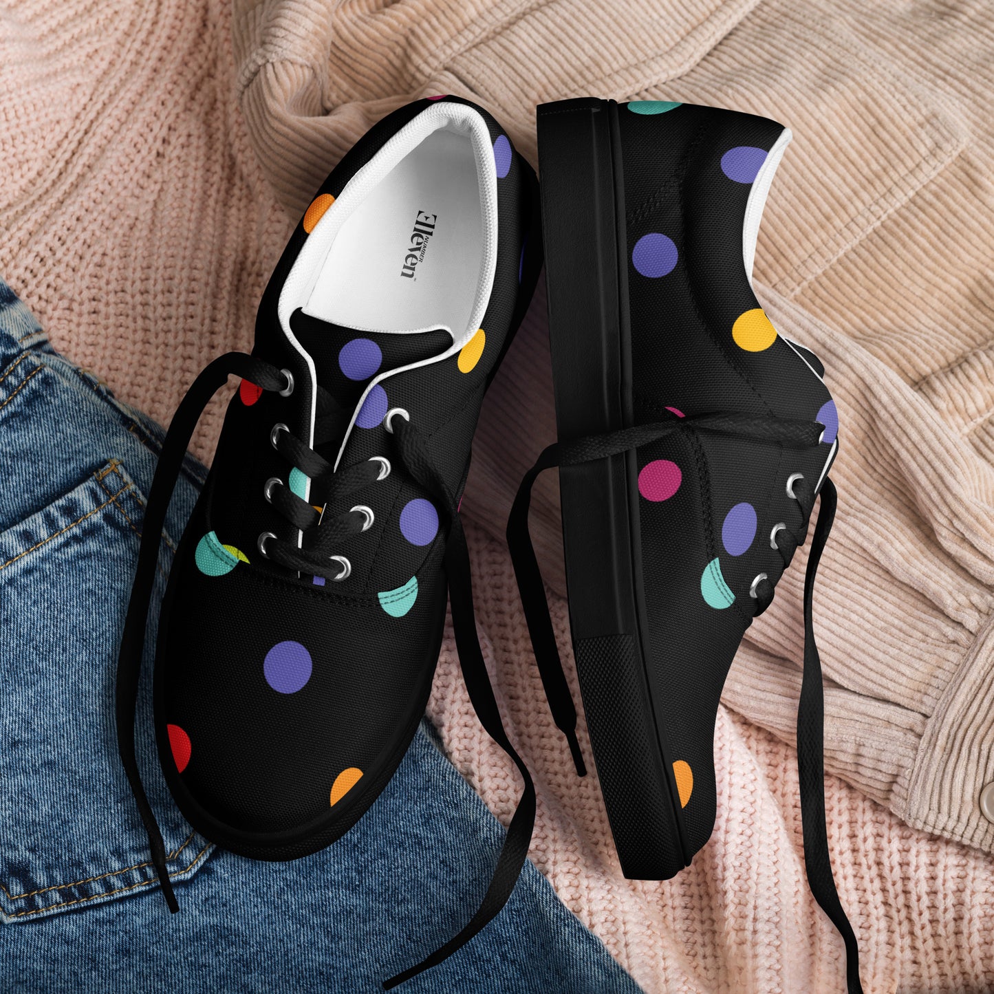 Women’s lace-up canvas shoes with colorful polka dots on black background
