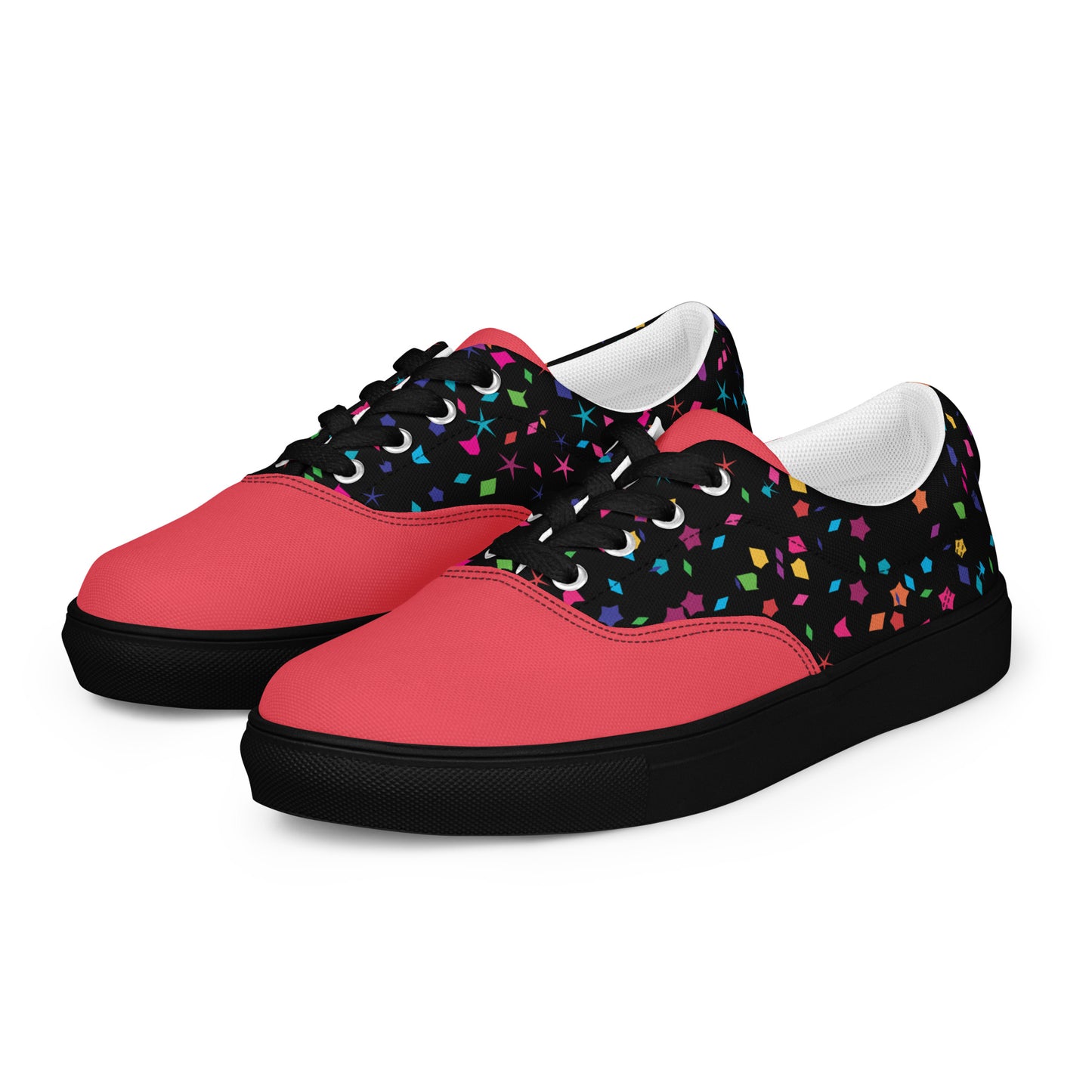 Angled pair of women’s lace-up canvas shoes with coral base, black upper, and colorful confetti details