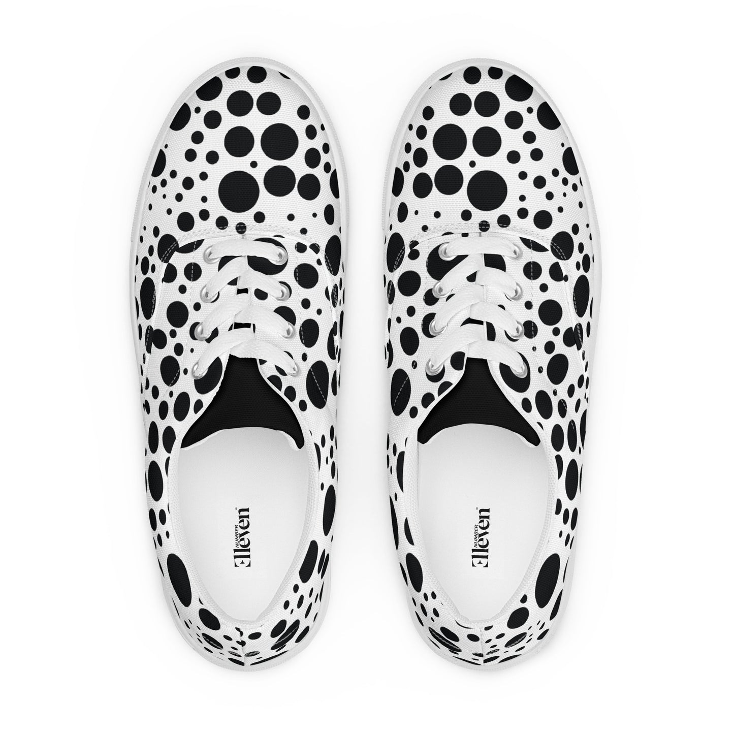 top view of women’s lace-up canvas shoes with varied black circle pattern on white background