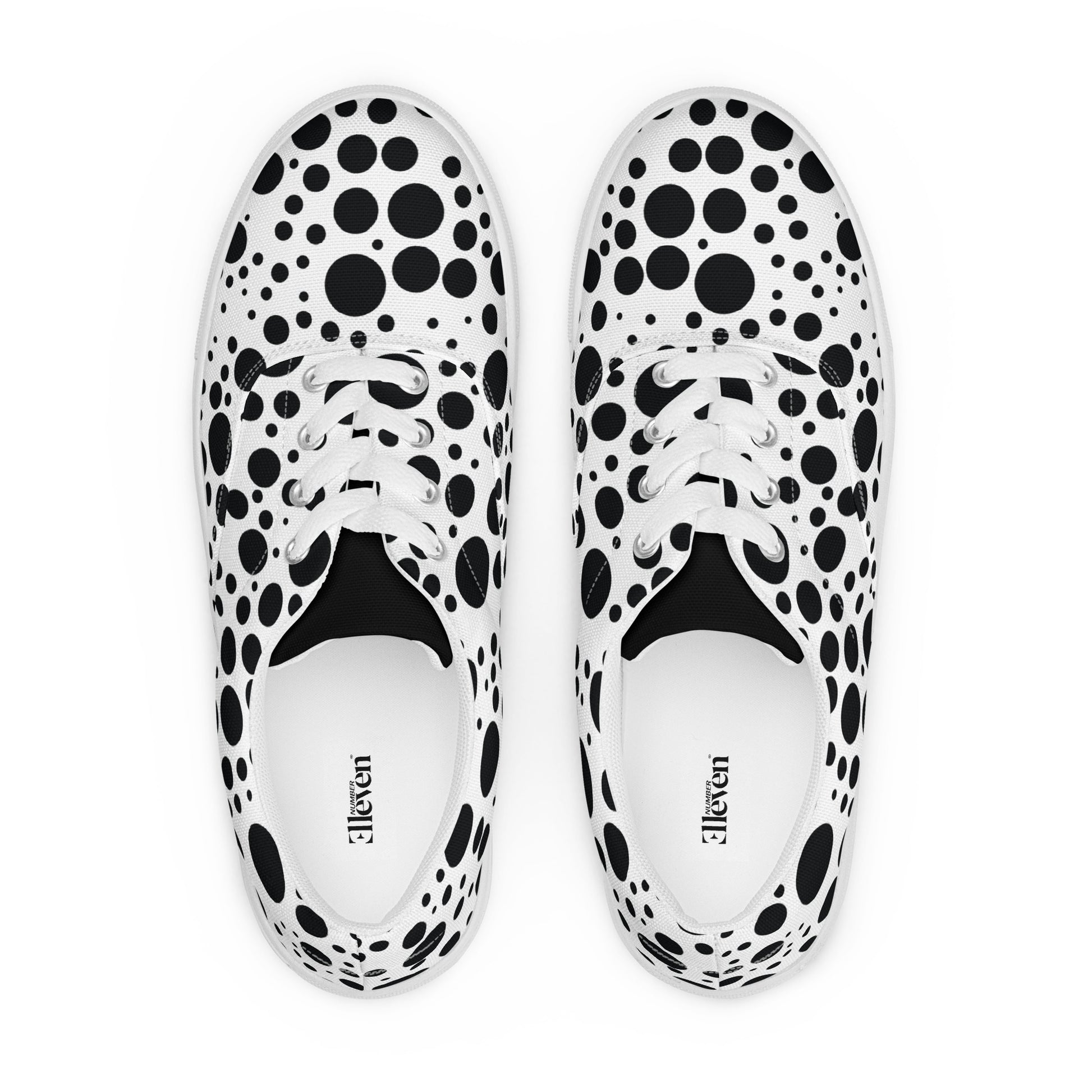 top view of women’s lace-up canvas shoes with varied black circle pattern on white background